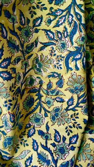 Handbedruckter Baumwollstoff mit blauen Blumen auf gelben Hintergrund